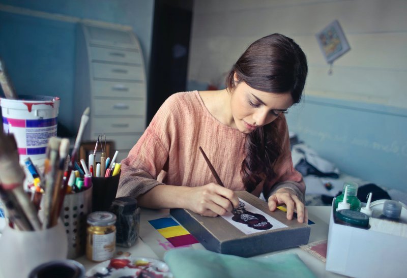 a girl drawing a logo using pencil and paper