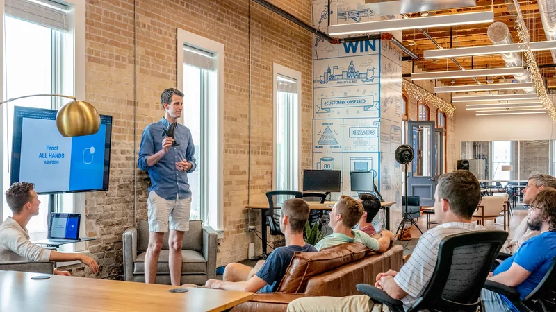 What Is Micro SaaS? What Do You Need To Know About Them? 1 A man speaking to a small group of people trying to market products for the niche market, an example of Micro Saas.